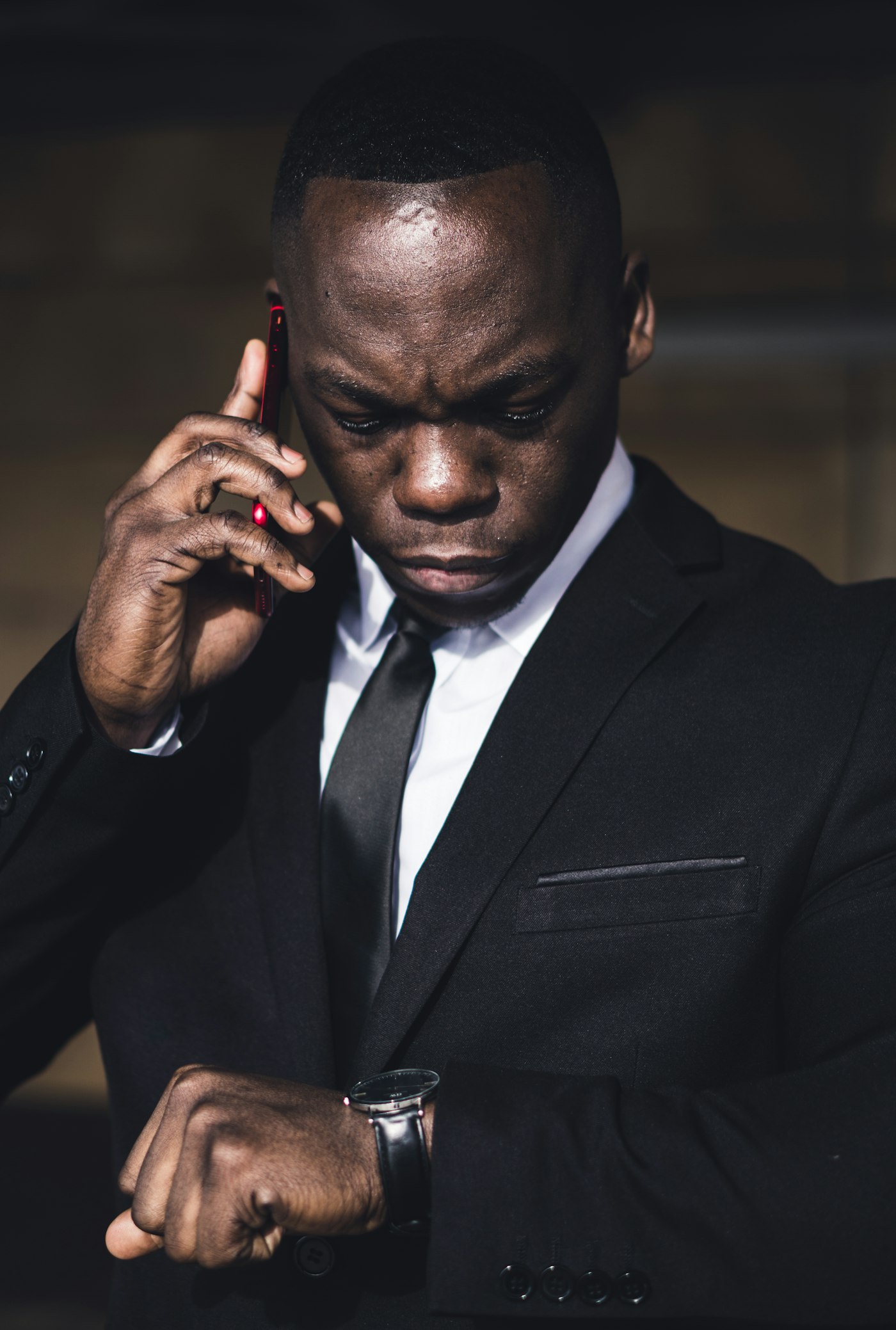 Agent de sécurité privée à Paris en costume sombre, coordonnant une mission par téléphone