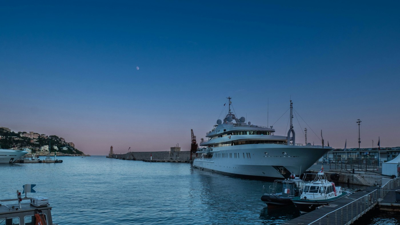 Port de Nice au crépuscule, yacht amarré devant la colline du Château